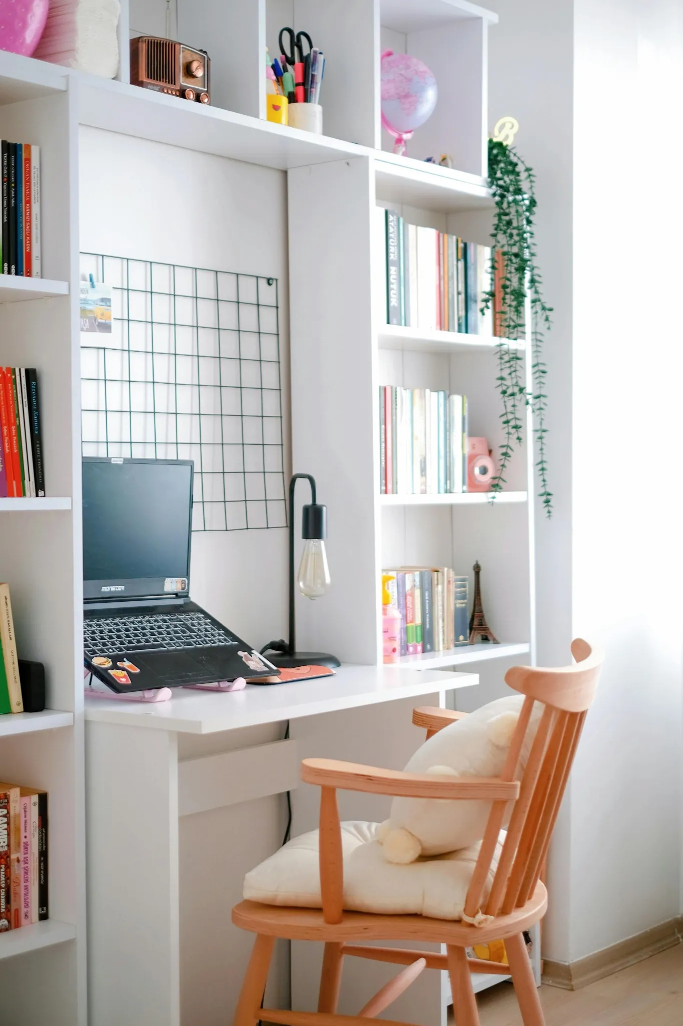 Minimalist home office with organized desk, laptop, and shelves in a decluttered workspace